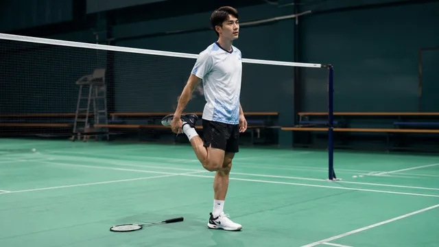 Pemain badminton melakukan cooldown dengan peregangan setelah bermain