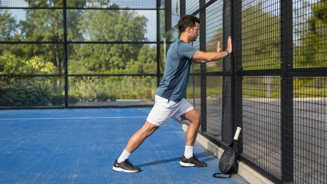 Pemain melakukan peregangan betis ringan setelah bermain padel