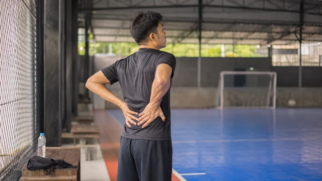 Pemain futsal melakukan peregangan pinggang setelah bermain